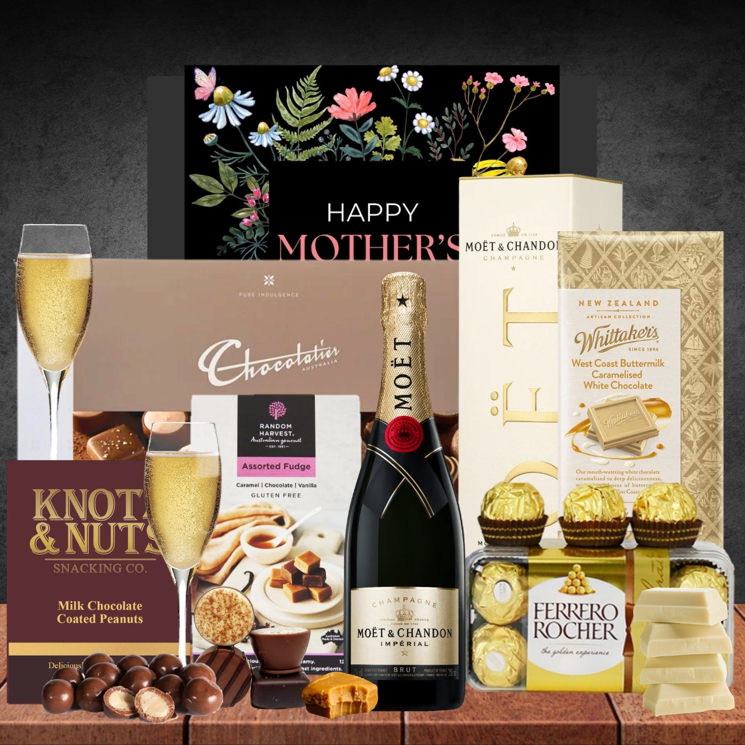 Gourmet gift basket with champagne, chocolates, and snacks on a wooden surface.