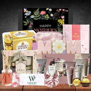 A Mother's Day gift set featuring chocolates, floral skincare, pink sleep mask, "MOM" cookies, and a floral card, conveying a warm, festive tone.