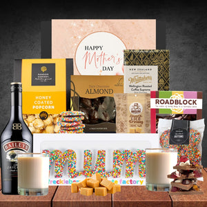 Gourmet gift basket with Mother's Day theme on a wooden surface.