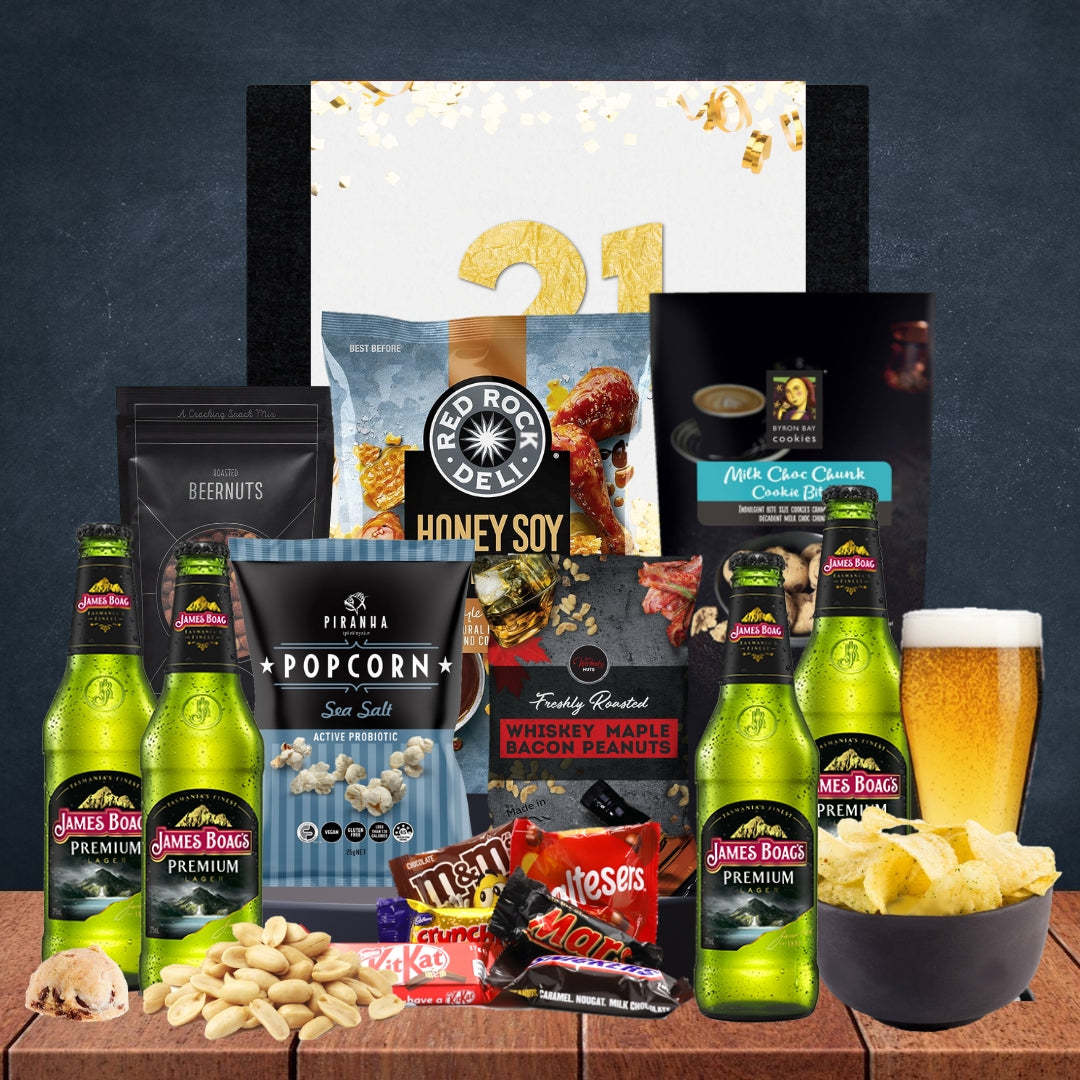 Gourmet gift set with beer, snacks, and a personalized card on a wooden surface.