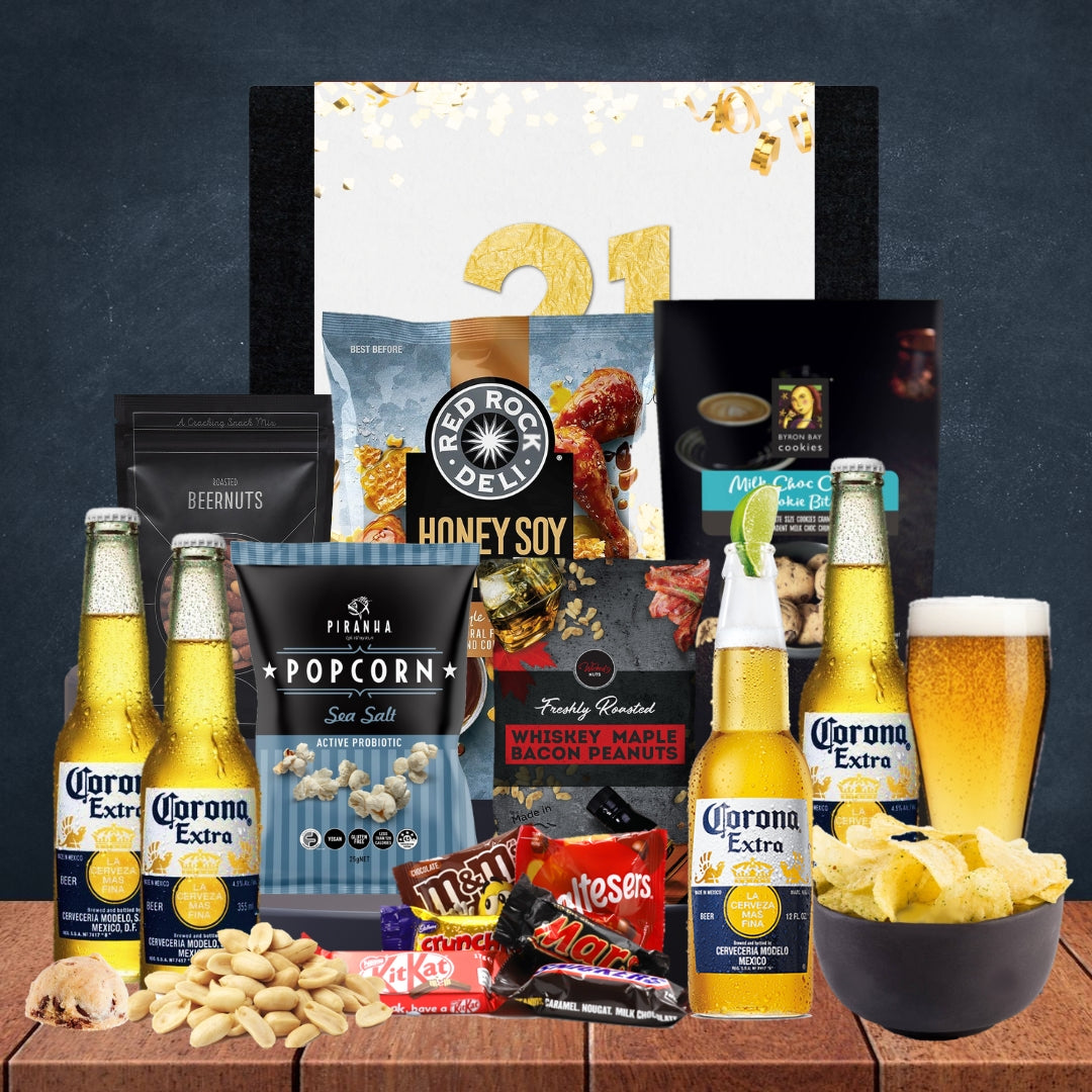 Gourmet gift set with Corona Extra beer, popcorn, and snacks on a wooden surface.